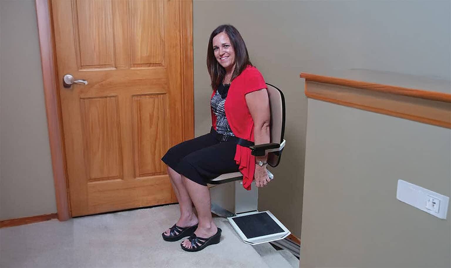 Homeowner seated on a stair chair beside her front door