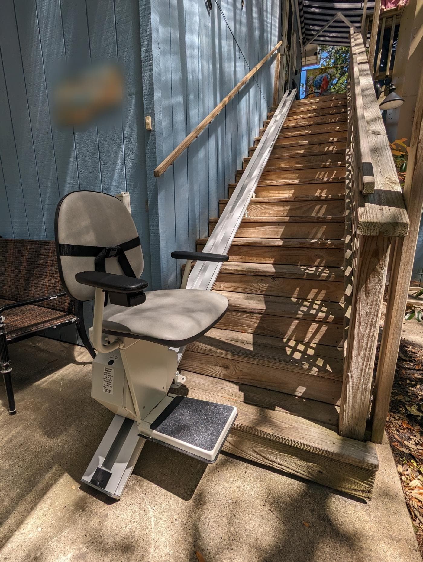 Stair chair installed at the foot of a long wooden staircase
